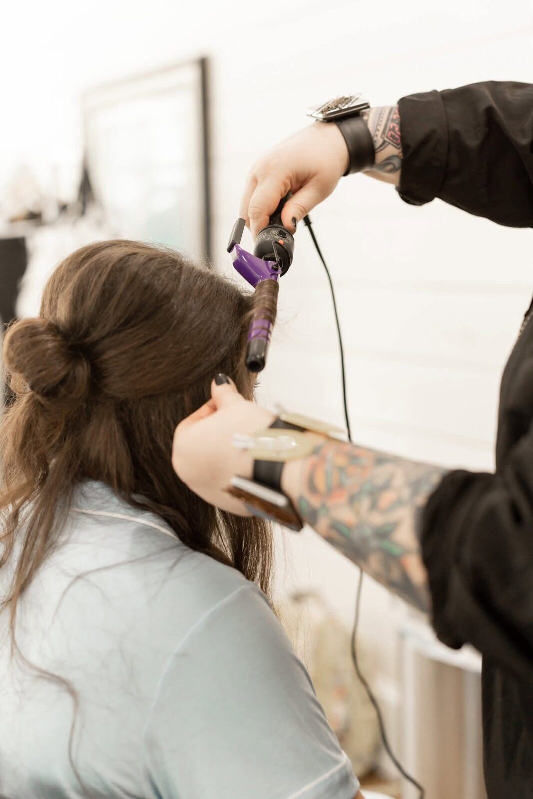 Amanda curling a bride's hair on the wedding day