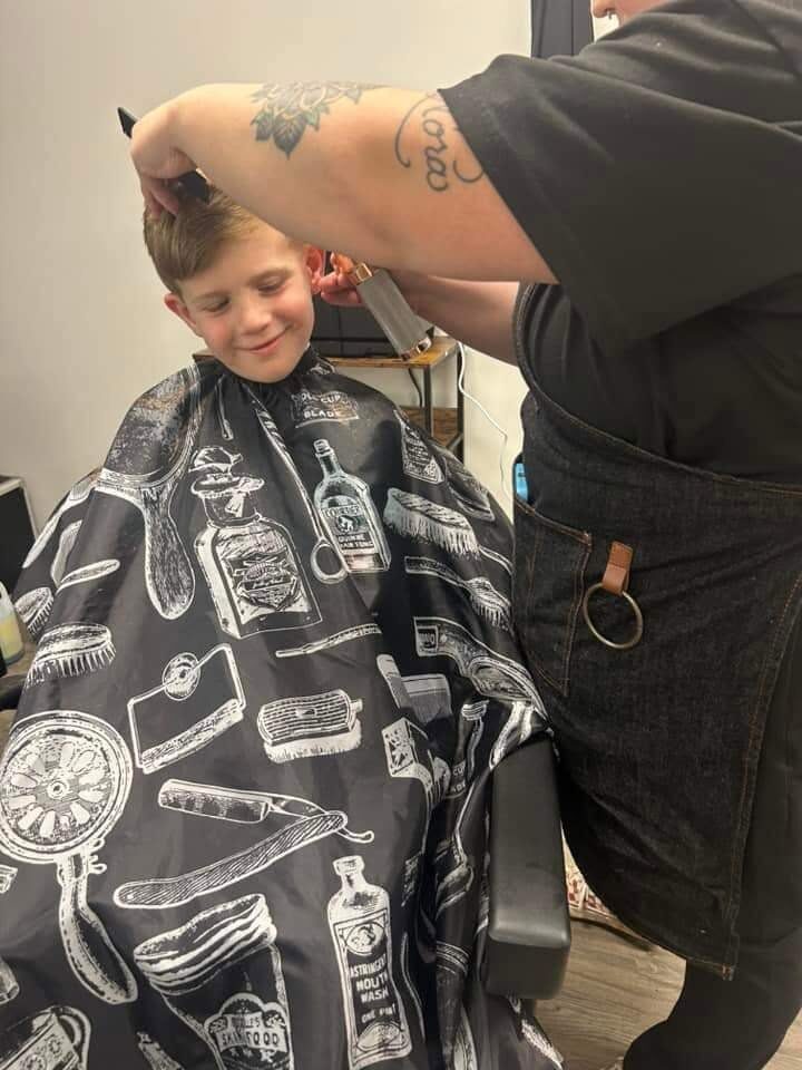 Young boy smiling during a clipper haircut