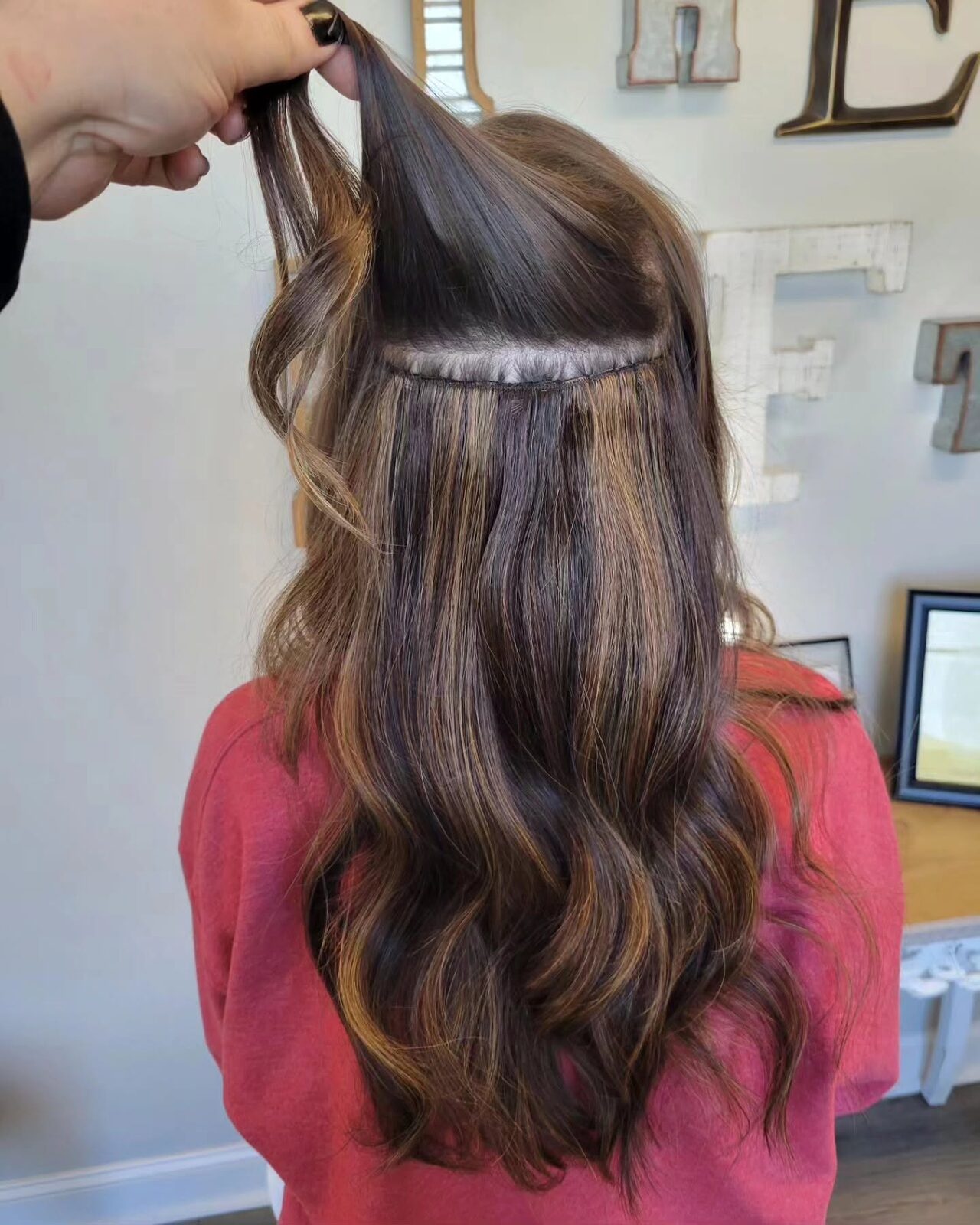 Hand-tied weft hair extensions being installed